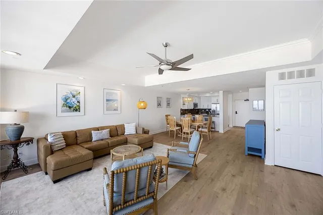 a living room with furniture kitchen view and a window