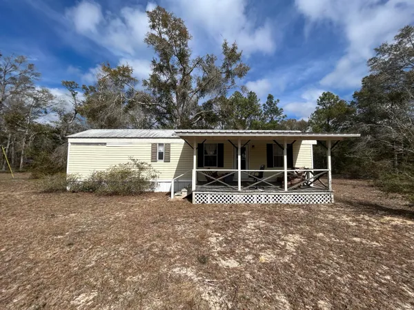front view of a house with a tree in the background