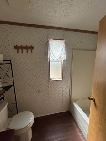 a bathroom with a granite countertop toilet a sink and bathtub