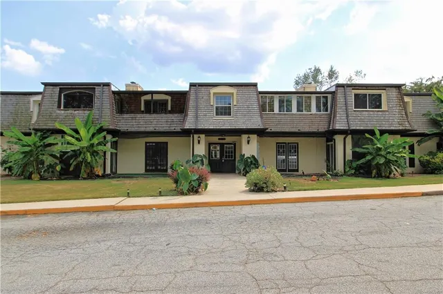 a front view of a house with a yard and plants