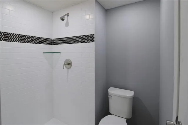a bathroom with a toilet and a shower