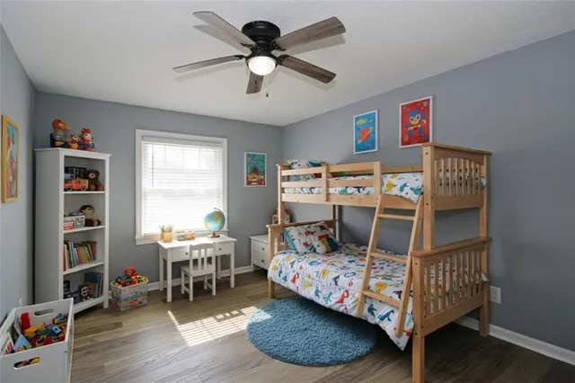 a bedroom with a bed a books bucket with a desk and chair