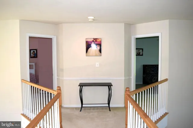 a view of a hallway with wooden floor and stairs