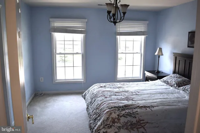 a bedroom with a bed a window and a chandelier