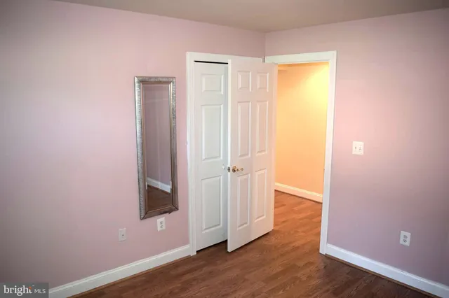 an empty room with wooden floor and closet