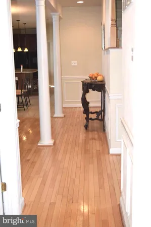 a hallway view with a large window and wooden floor