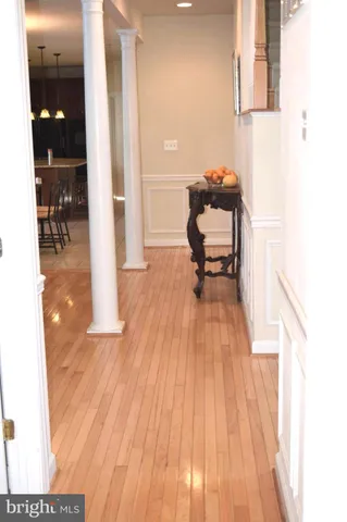 a hallway view with a large window and wooden floor