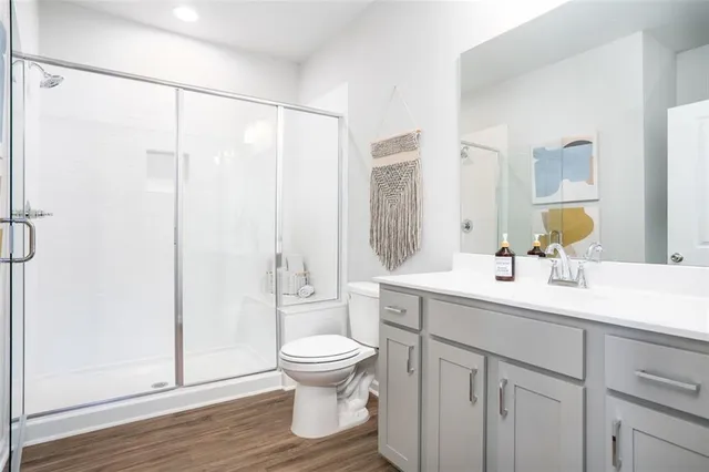 a bathroom with a sink toilet a mirror and shower