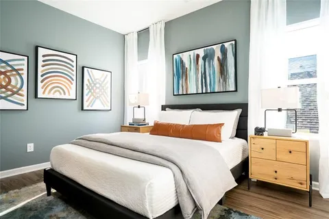 a bedroom with a bed and a painting on the wall