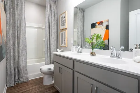 a bathroom with a double vanity sink toilet and shower