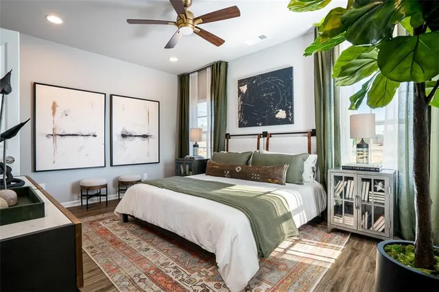 a bedroom with a bed a table and painting on the wall