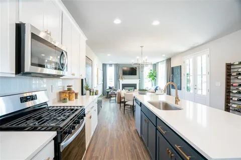 a kitchen with stove a sink dishwasher and a stove top oven with wooden floor