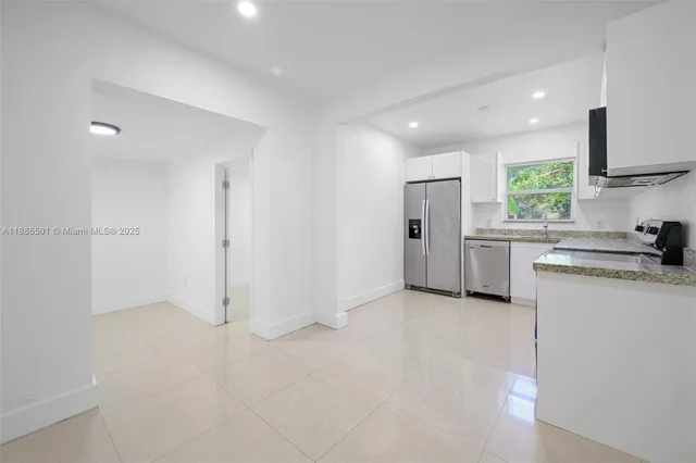 a kitchen with white cabinets and stainless steel appliances