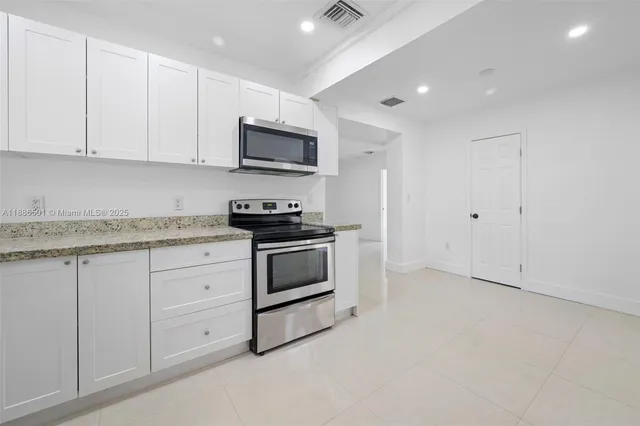 a view of a kitchen with a sink and dishwasher a refrigerator wooden cabinets
