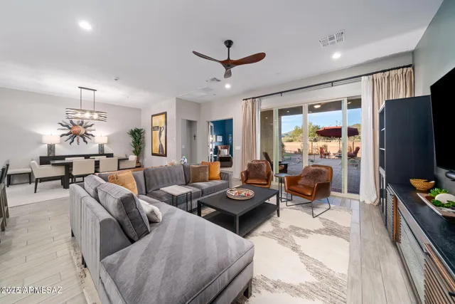 a living room with furniture kitchen view and a large window