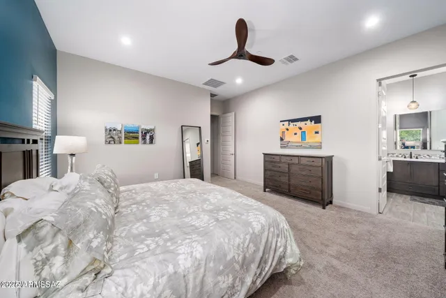 a spacious bedroom with a bed and a flat screen tv