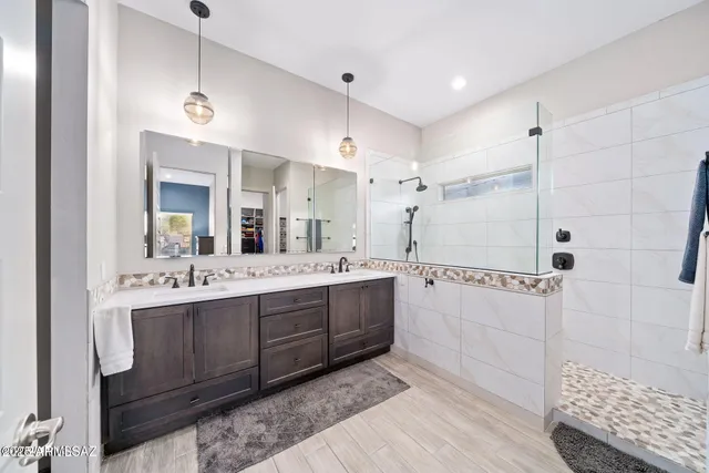 a bathroom with a double vanity sink mirror and shower