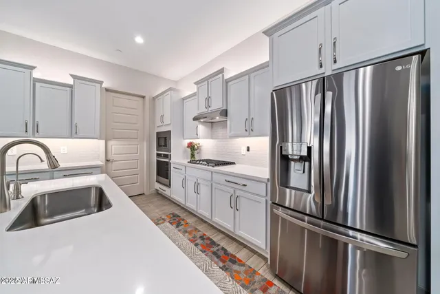 a kitchen with stainless steel appliances a refrigerator sink and cabinets