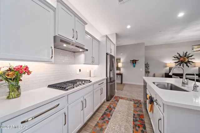 a kitchen with granite countertop a sink stove and cabinets