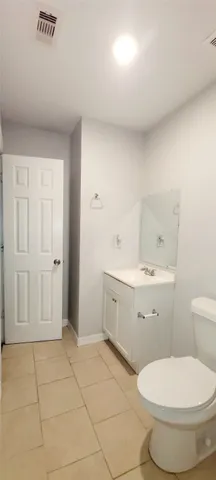 a bathroom with a sink a toilet and large mirror