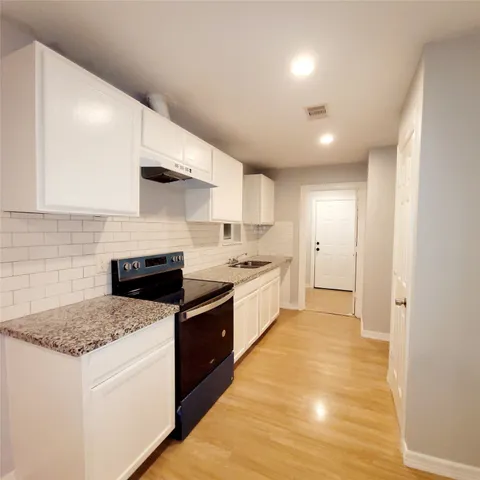a large kitchen with stainless steel appliances granite countertop a stove and a sink