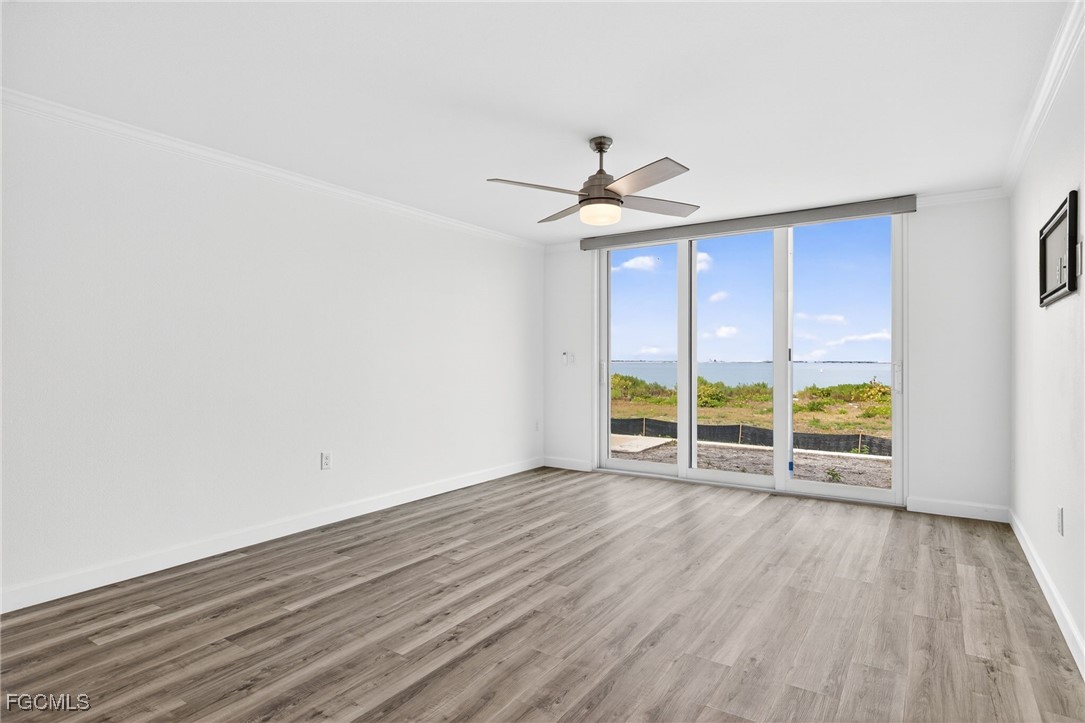 200 Periwinkle Way, Unit 124 Sanibel, FL 33957 - Photo 11 of 50 an empty room with wooden floor and windows
