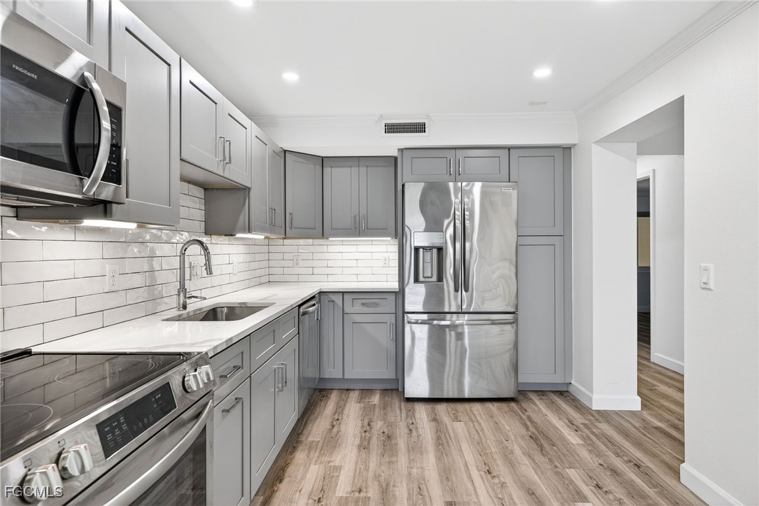 200 Periwinkle Way, Unit 124 Sanibel, FL 33957 - Photo 14 of 50 a kitchen with stainless steel appliances granite countertop a refrigerator and a sink