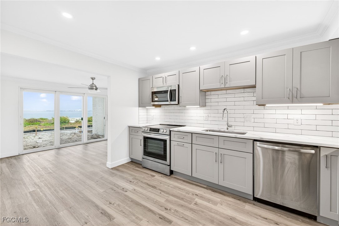 200 Periwinkle Way, Unit 124 Sanibel, FL 33957 - Photo 15 of 50 a kitchen with granite countertop a stove top oven sink and cabinets