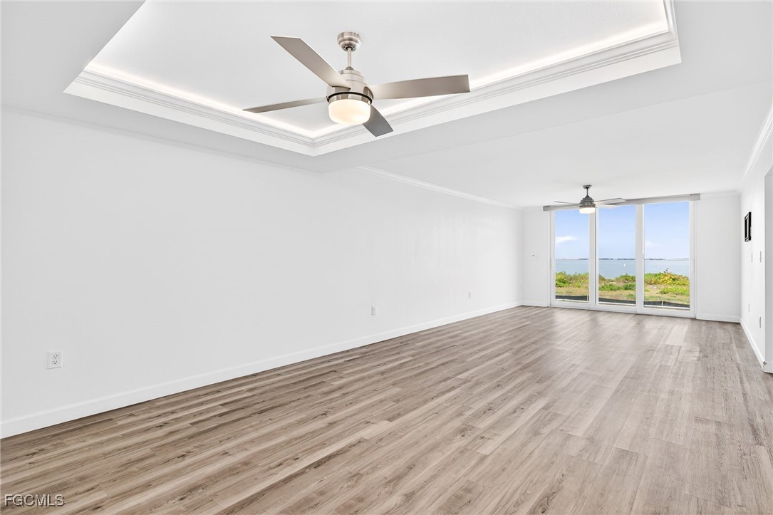 200 Periwinkle Way, Unit 124 Sanibel, FL 33957 - Photo 18 of 50 an empty room with wooden floor ceiling fan and windows