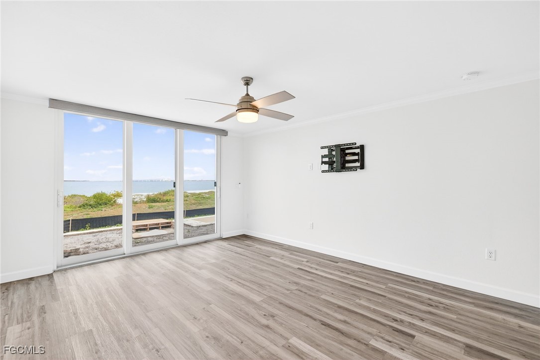 200 Periwinkle Way, Unit 124 Sanibel, FL 33957 - Photo 24 of 50 an empty room with wooden floor and windows