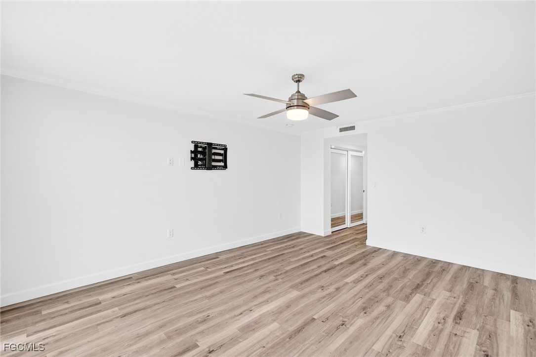 200 Periwinkle Way, Unit 124 Sanibel, FL 33957 - Photo 27 of 50 an empty room with wooden floor and ceiling fan
