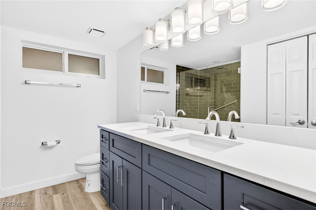 200 Periwinkle Way, Unit 124 Sanibel, FL 33957 - Photo 29 of 50 a bathroom with a sink a toilet and a mirror