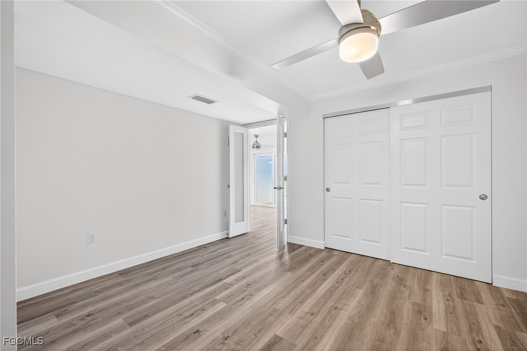 200 Periwinkle Way, Unit 124 Sanibel, FL 33957 - Photo 30 of 50 an empty room with wooden floor and windows
