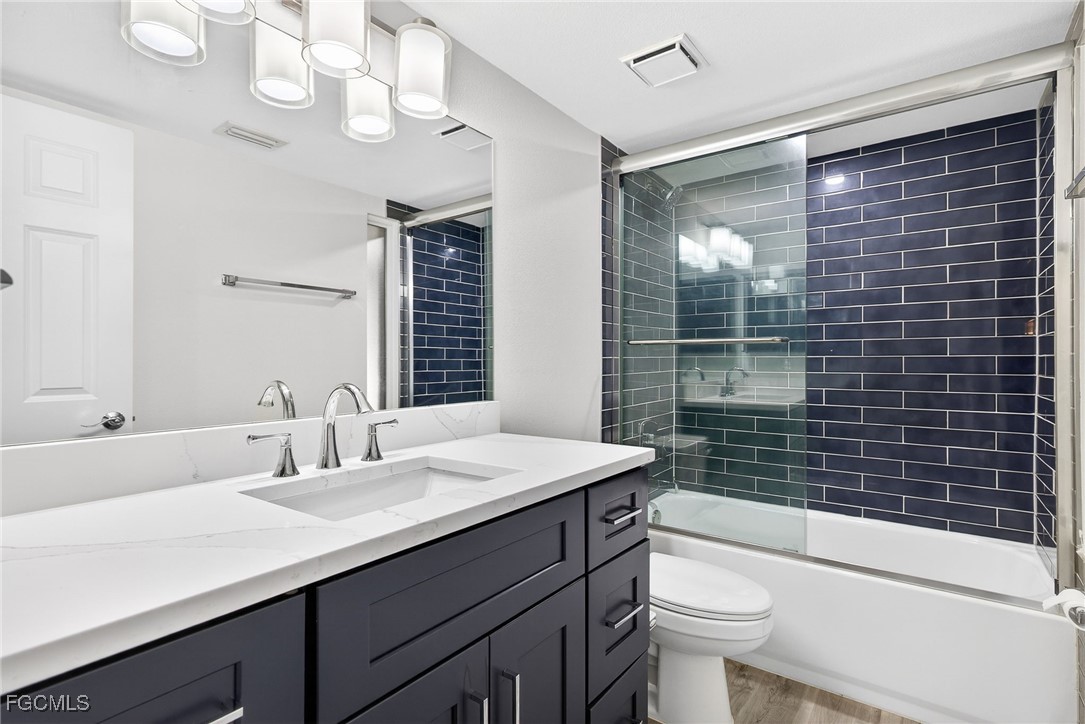 200 Periwinkle Way, Unit 124 Sanibel, FL 33957 - Photo 32 of 50 a bathroom with a sink a toilet a mirror a vanity and shower