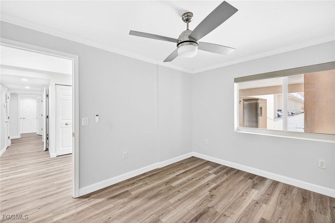 200 Periwinkle Way, Unit 124 Sanibel, FL 33957 - Photo 33 of 50 a view of empty room with wooden floor and fan