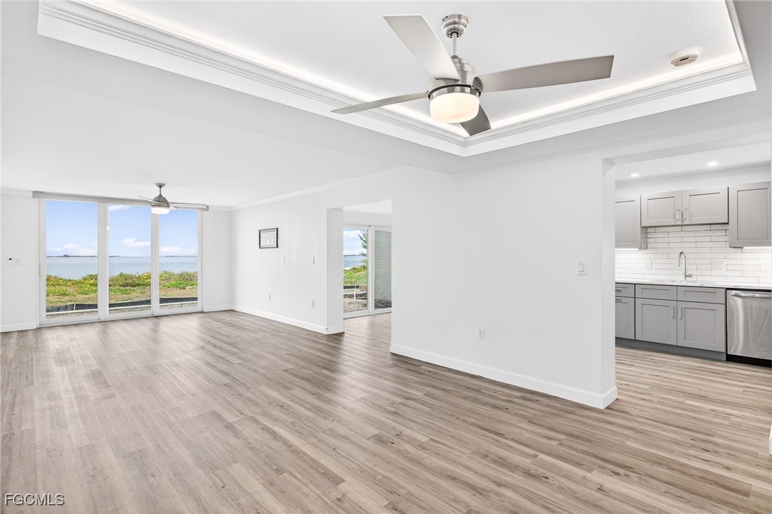 200 Periwinkle Way, Unit 124 Sanibel, FL 33957 - Photo 5 of 50 a view of a kitchen with a sink dishwasher a refrigerator cabinets and wooden floor