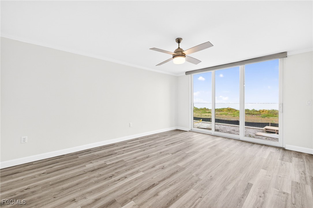 200 Periwinkle Way, Unit 124 Sanibel, FL 33957 - Photo 7 of 50 an empty room with wooden floor fan and windows
