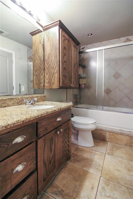1001 Sandy Ridge Road Scurry, TX 75158 - Photo 23 of 35 Bathroom featuring a single vanity with a granite countertop, undermount sink, and wood-finish cabinetry