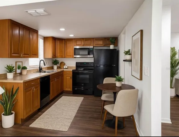 a kitchen with stainless steel appliances kitchen island granite countertop a refrigerator a sink dishwasher a stove with wooden cabinets and floor
