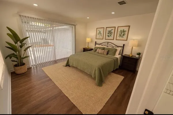 a bed sitting in a spacious bedroom next to a window