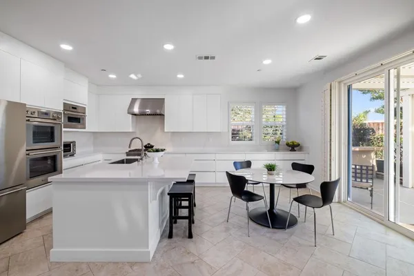 a kitchen with appliances a sink a counter top space and cabinets