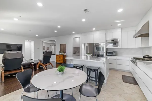 a view of kitchen with refrigerator stove dining table and chairs
