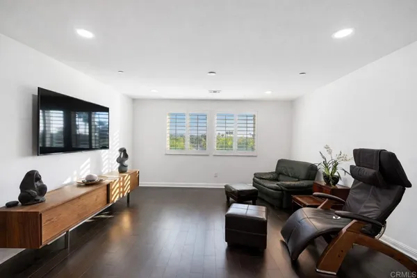 a spacious bedroom with a bed and wooden floor