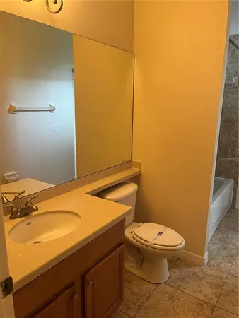 a bathroom with a granite countertop toilet and a sink