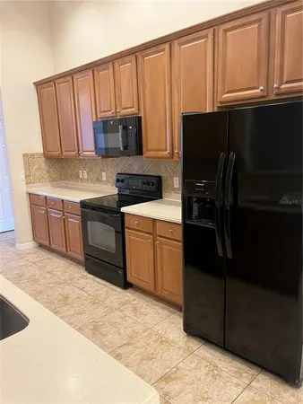 a kitchen with stainless steel appliances granite countertop a stove a sink dishwasher and a refrigerator