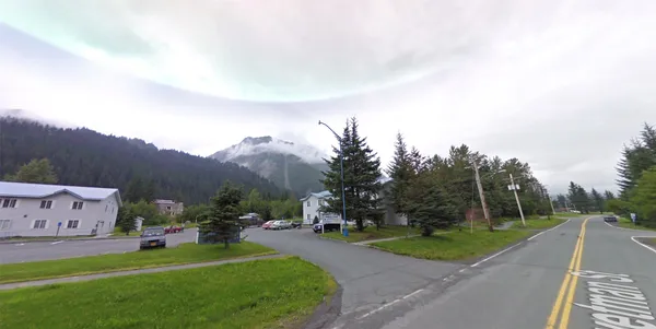 a sign board with buildings in the background