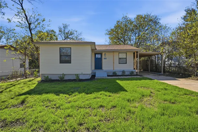 a view of a house with backyard and a tree