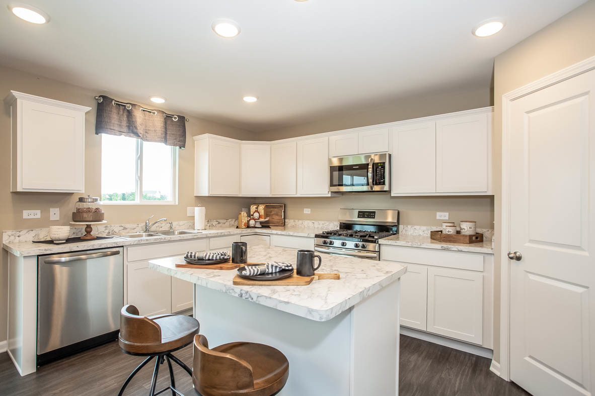 3818 Doherty Lane McHenry, IL 60050 - Photo 4 of 10 a kitchen with a sink stove and white cabinets
