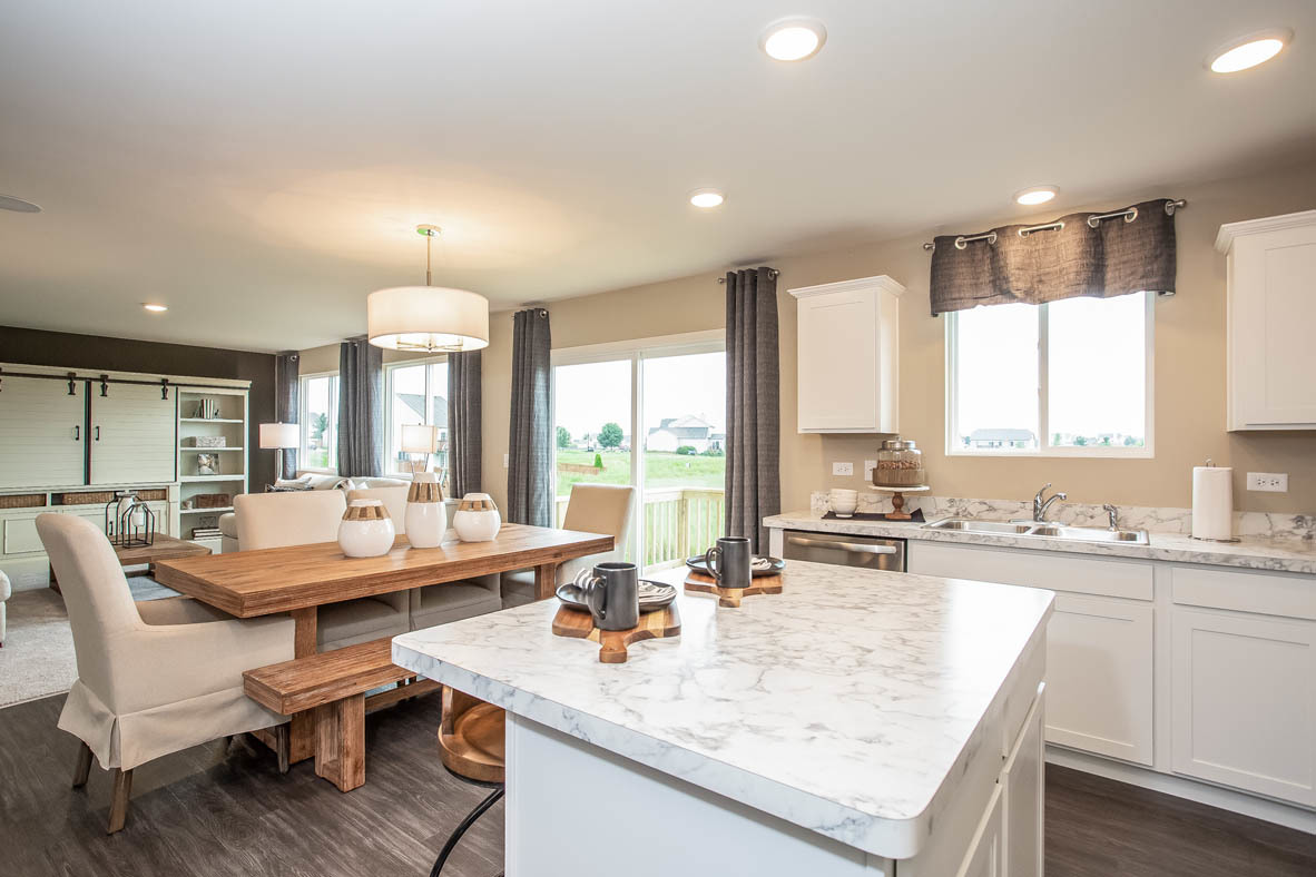 3818 Doherty Lane McHenry, IL 60050 - Photo 6 of 10 a large kitchen with kitchen island granite countertop a stove a sink a dining table and chairs