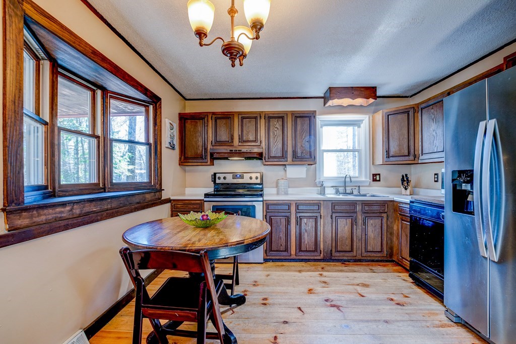 103 Dunn Road Ashburnham, MA 01430 - Photo 3 of 30 a kitchen with sink refrigerator dining table and chairs